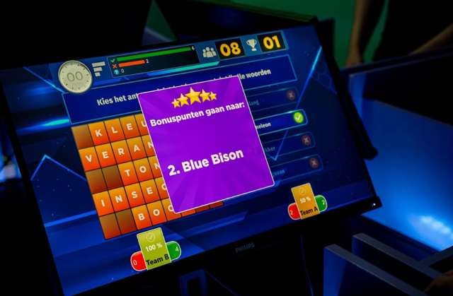 Quiz screen showing a word grid, live team scores and a bonus-points overlay